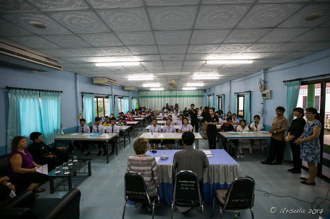 Fluorescent-lit Department of Education Office with students waiting at tables, Mae Sariang Thailand