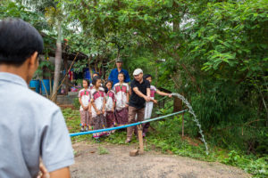 Thai man with a Water hose, Ban Mae Pae, Mae Hong Son Thailand