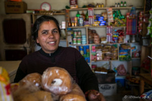 Smiling Nepali woman in a general store, Panauti-Namobuddha Rd, Nepal