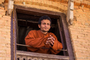 Nepali man in a window, Panauti-Namobuddha Rd, Nepal