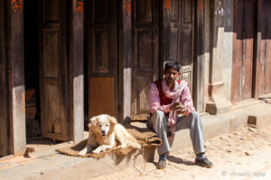 A Man and his Dog in front of teak louvre doors, Panauti-Namobuddha Rd, Nepal