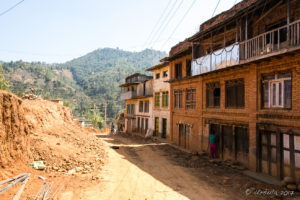 Dusty Street with three-story houses one side, Panauti-Namobuddha Rd, Nepal