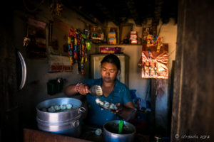 Newari woman dishing up freshly steamed dumplings, Panauti-Namobuddha Rd, Nepal