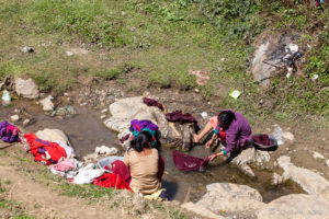 Newari women doing laundry in a creek, Panauti-Namobuddha Rd, Nepal