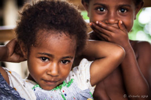 Portrait of young Papuan girl with her laughing brother behind her, Maprik PNG