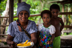 Old Papuan woman in a hat with two toddlers, roadside market, Maprik PNG