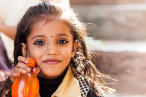 Portrait of a young Indian girl with an orange drink, Amer Fort Jaipur, India