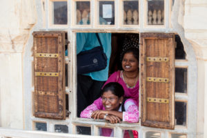 Indian women at a shuttered window, Amer Palace, Jaipur India