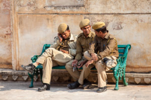 Three Indian men in guard's uniform on a bench, Amer Palace, Jaipur India