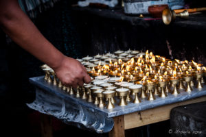 A man lighting candles, Thrangu Tashi Yangtse Monastery, Namo Buddha Nepal
