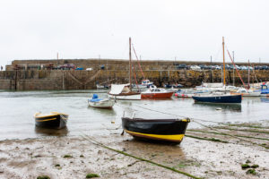 Small boats anchored on Mousehole wharf, Cornwall UK