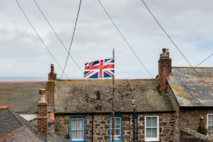 A Union Jack flying over Mousehole rooftops, Cornwall UK