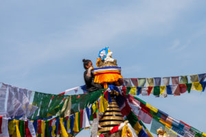 Affixing A Nepali man attaching prayer flags to Namo Buddha Stupa, Nepal