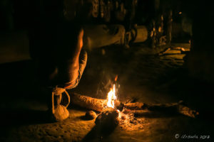 Firelight in a spirit house, illuminating a crocodile man's scars, Kanganaman Village, PNG