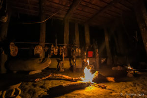 Firelight in a spirit house, illuminating the Sacred Carvings, Kanganaman Village, PNG
