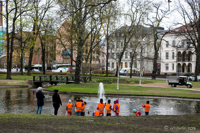 Children in hi-vis vests at a pond in Slottsparken, Oslo Norway
