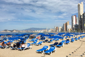 Blue beach lounge chairs, Benidorm Spain