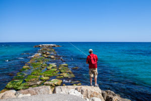 Recreational fisherman on the rocky pier, Villajoyosa, Spain
