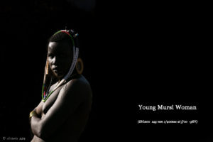Underexposed bright-rim-light picture of a young Mursi woman, Ethiopia