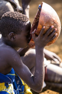 Young Mursi man drinking blood, Ethiopia