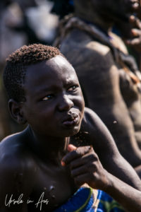 Young Mursi man drinking blood, Ethiopia