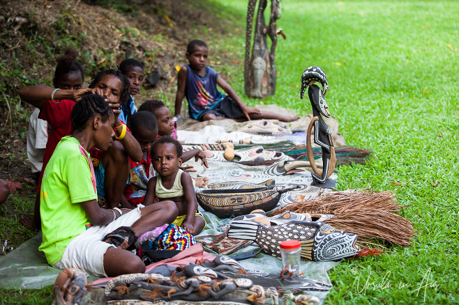Papuan women and children gathered on mats with goods for sale, Kanganaman Village, PNG