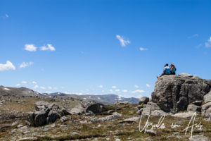 People sitting on a granite rock, Mt Kosciuszko Lookout, Australia