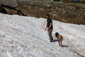 Father and daughter playing in the summer snow, Mt Kosciuszko walkway, Australia
