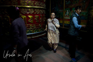 Nepali woman walking around a prayer wheel, Boudhanath Stupa, Kathmandu.