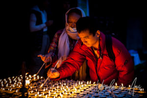 Tibetan Buddhists lighting candles at Boudhanath Stupa, Kathmandu.
