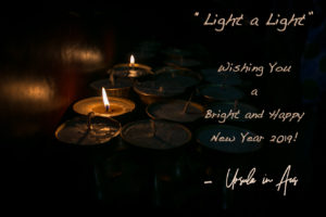 Photo: Buddhist candles in the dark. Text: Happy new year