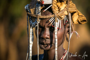 Mursi woman in a headdress of metal, leather, towelling and beads, Omo Valley Ethiopia