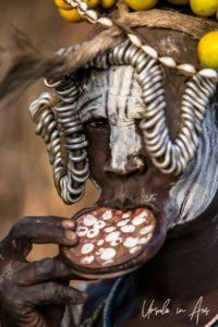 Mursi woman in a metal headdress and lip plate, Omo Valley Ethiopia