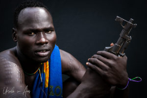 Portrait of Mursi man and his weapon, Ethiopia