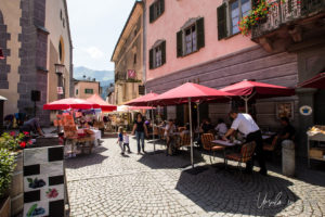 Restaurant tables and umbrellas, Piazza Comunale, Poschiavo, Switzerland