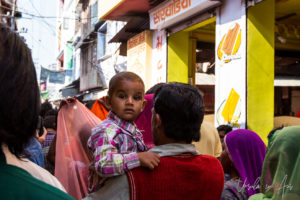 Indian child looking over his father's shoulder, Pushkar