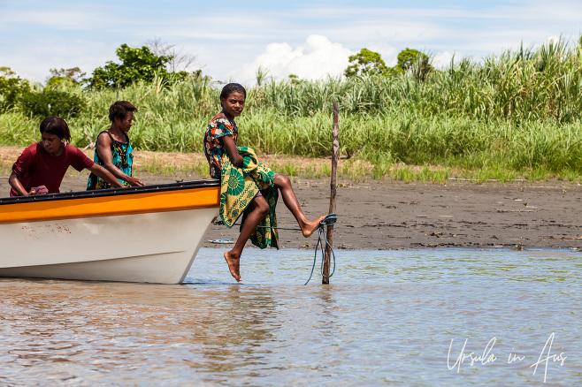 Papuan girl sitting on the prow of a Boat, Sepik River PNG