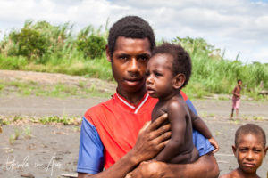 Young Papuan man with a baby, Sepik River