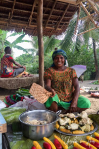 Papuan woman fanning her foods, Maprik Market PNG