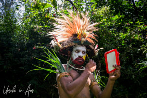 Huli wigman applying facepaint, Paiya Village Papua New Guinea
