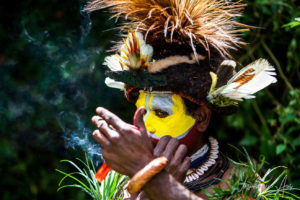 Huli wigman applying facepaint, Paiya Village Papua New Guinea