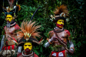 Three Huli Wigmen in full paint and headdress, Paiya Village Papua New Guinea