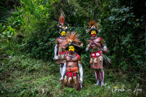 Three Huli Wigmen in full paint and headdress, Paiya Village Papua New Guinea