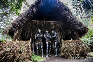 Skeleton men in the doorway of a hut, Paiya Village Papua New Guinea