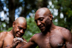 Bugamo men painting each other, Paiya Village Papua New Guinea
