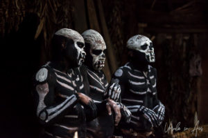 Skeleton men in the doorway of a hut, Paiya Village Papua New Guinea