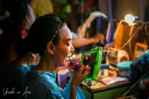 Chinese opera performer applying lipstick in a mirror, Chao Zhou Shi Kong Shrine, Bangkok