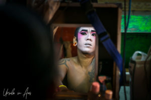 Chinese opera performer applying makeup in a mirror, Chao Zhou Shi Kong Shrine, Bangkok