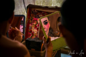 Chinese opera performers applying lipstick in a mirror, Chao Zhou Shi Kong Shrine, Bangkok