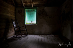Single rocking chair inside the dark George Adderley House, Crane Point, Marathon Key, Florida USA
